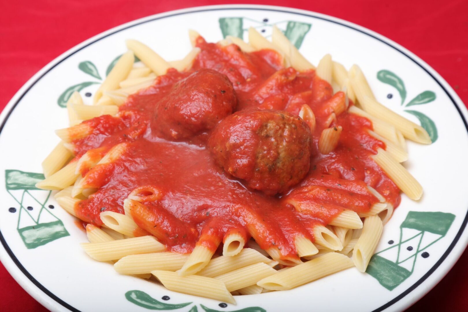 A plate of pasta and meatballs on top of the table.
