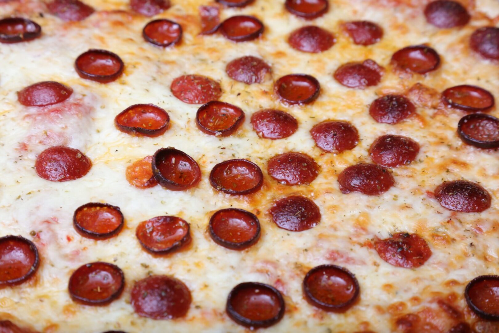 A pepperoni pizza with many pieces of it.